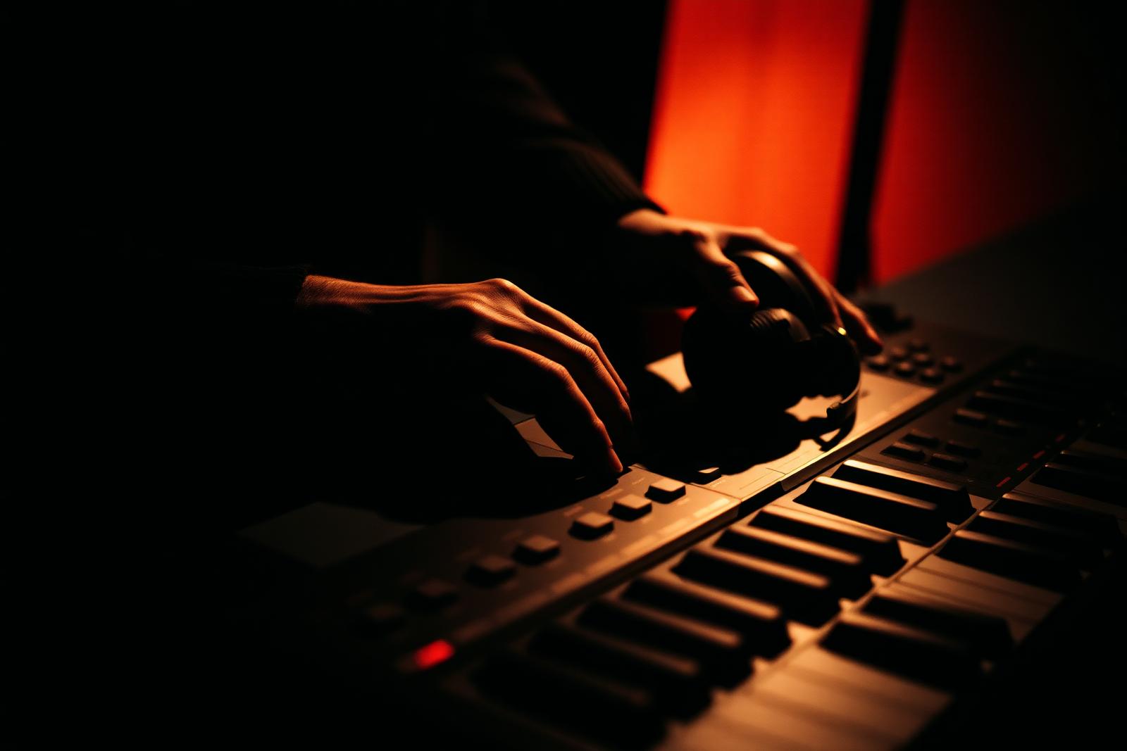 Keyboard controller and headphones in warm low light